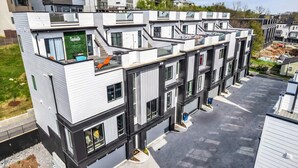 A modern multi-story residential building with balconies, large windows, and a green sign indicating a location. - Nashville escape with hot tub, karaoke lounge & makeup bar, sleeps 12 (Nashville)