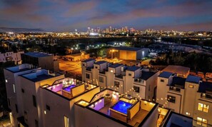 A modern hotel with rooftop pools and a city skyline view.