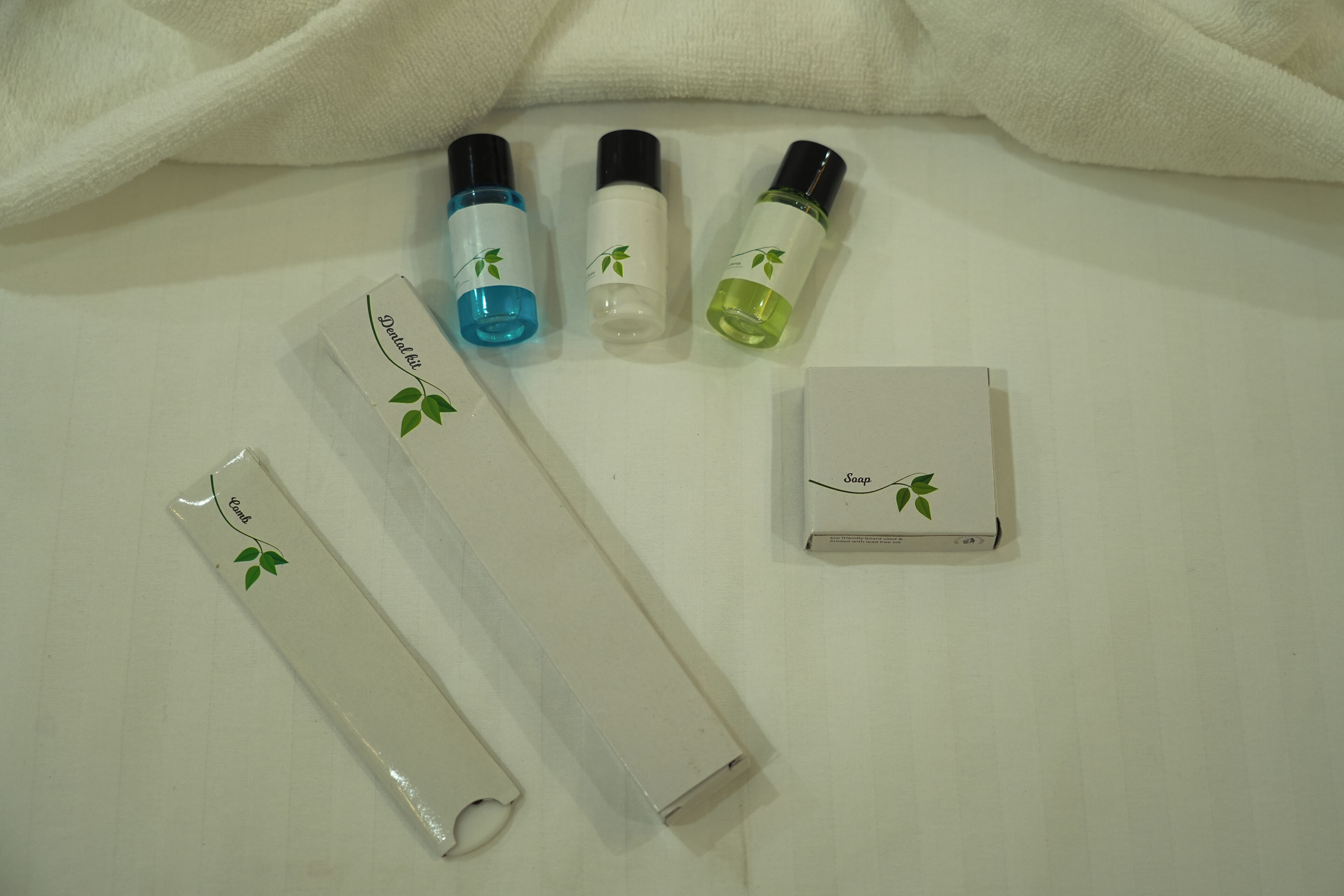 A set of toiletries including a toothbrush, toothpaste, and a soap bar on a white surface.