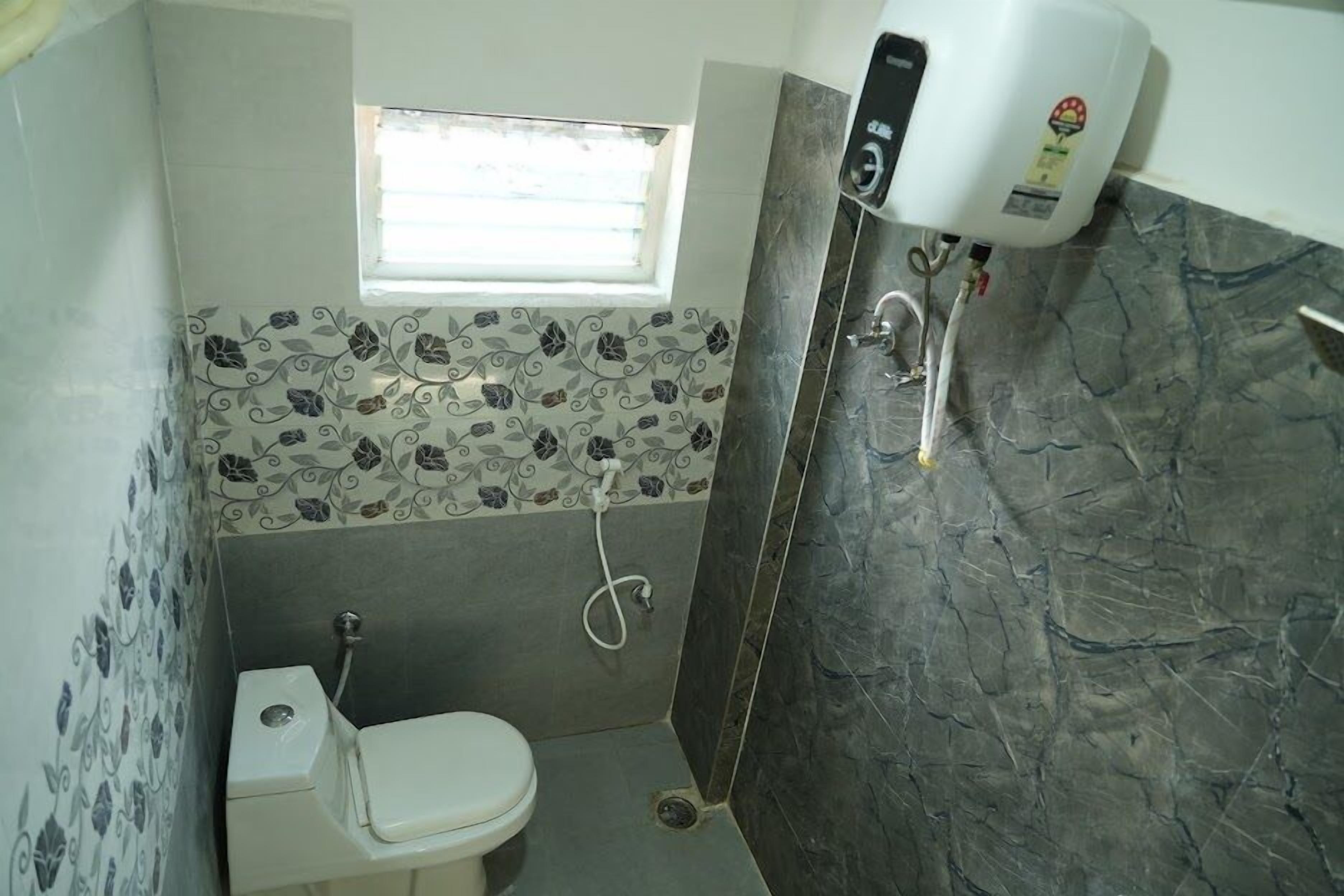A small bathroom with a toilet, a shower, and a water heater.