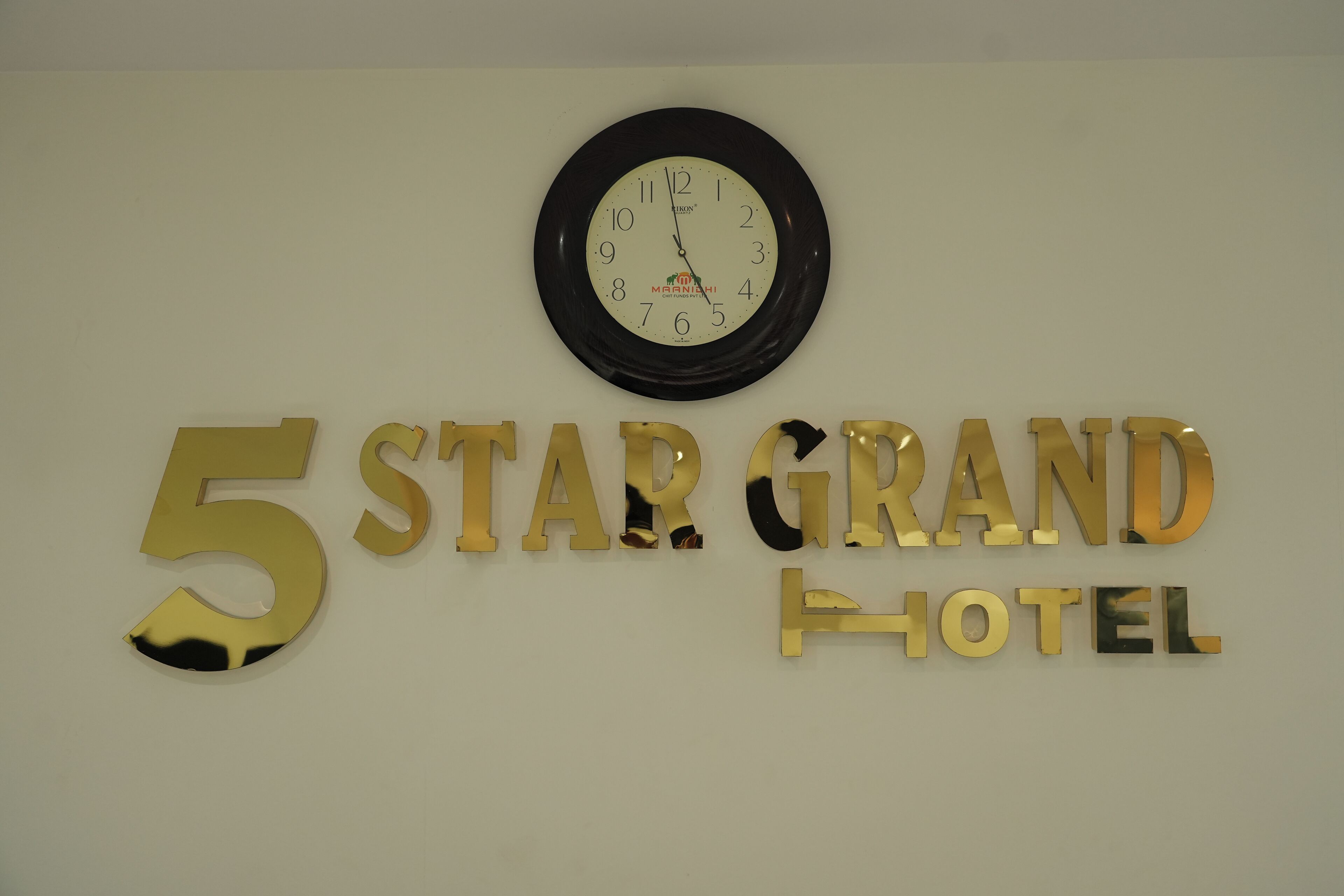 Una pared con un reloj y el texto "5 STAR GRAND HOTEL".