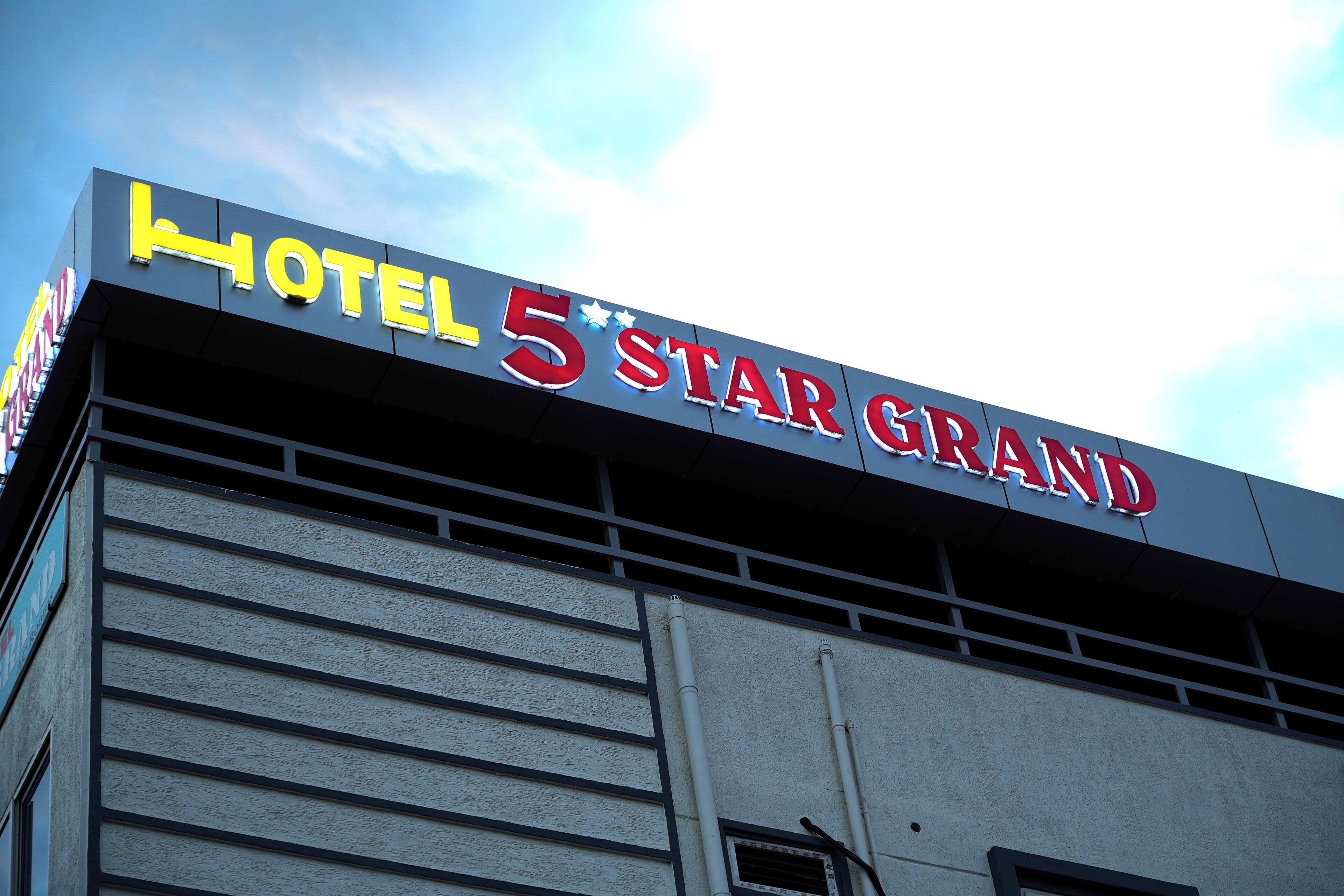Placa de hotel com o nome 'HOTEL 5 STAR GRAND'.