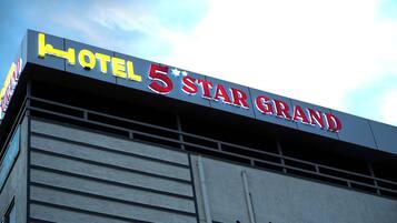 Placa de hotel com o nome 'HOTEL 5 STAR GRAND'.