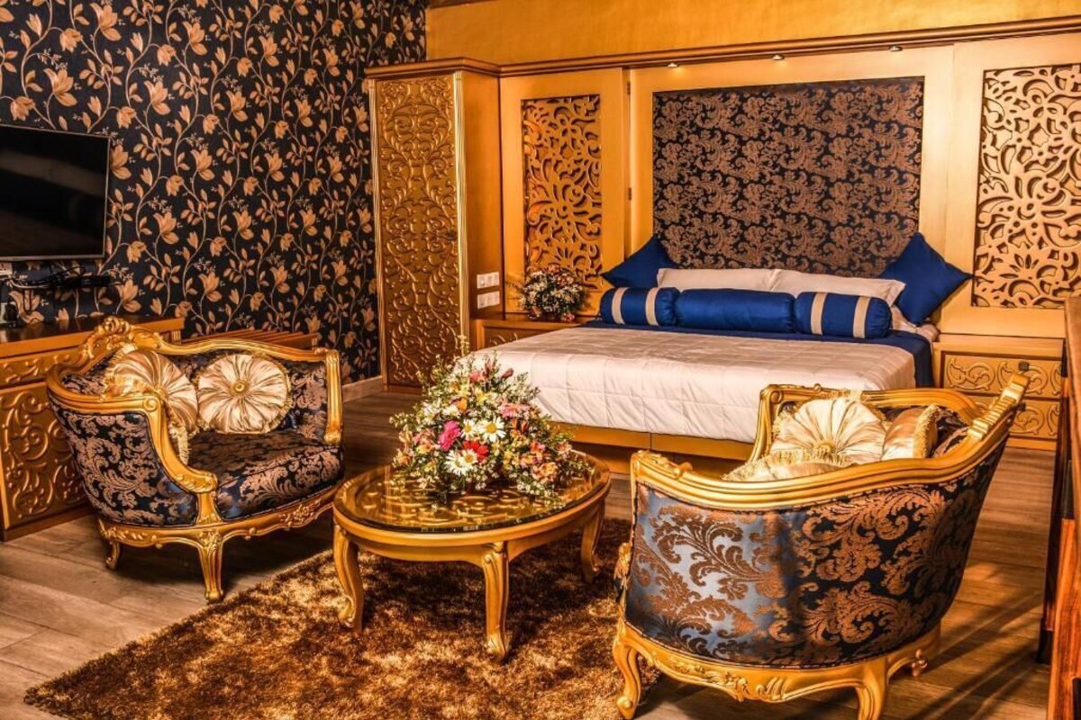 A luxurious bedroom with a large bed, ornate furniture, and floral decorations.