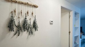 Ein Zimmer mit weißer Wand, einer hölzernen Windschleuder an der Decke und einer weißen Tür, die in ein weiteres Zimmer führt.