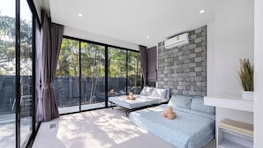 A modern bedroom with a large window, a stone wall, and a built-in air conditioning unit. - AnB Loft 1 poolvilla close Jomtian beach (Bang Lamung)