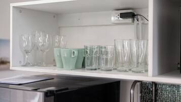 A kitchen cabinet with various glassware, including wine glasses and tumblers.