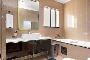 A modern bathroom with a large mirror, a white sink, a bathtub, and a glass-enclosed shower area. - Craigavon House by Tanaka Kingdom  (Fourways)