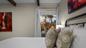 A bedroom with a bed, pillows, a window with curtains, and a painting on the wall. - Chic Zen-Inspired Oasis w/ Patio & Red Rock Views (Sedona)