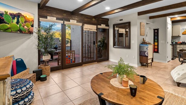 A spacious living area with a wooden dining table, a sofa, and a view of a garden through glass doors. - Chic Zen-Inspired Oasis w/ Patio & Red Rock Views (Sedona)