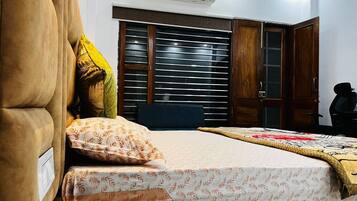 Un dormitorio con cama, armario y aire acondicionado.