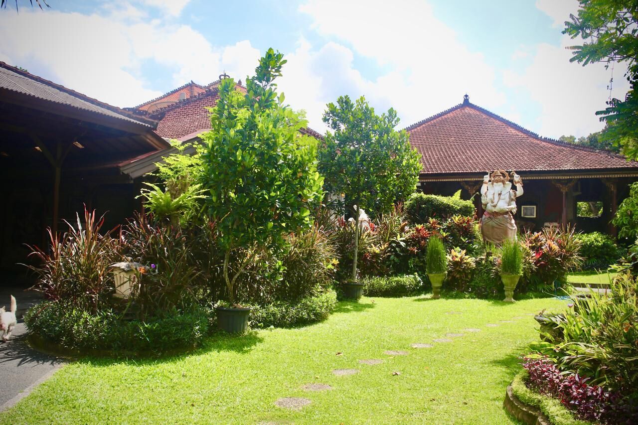 A garden with a pathway leading to a building with a red-tiled roof.