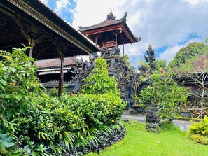 A traditional Balinese temple with intricate carvings and a lush garden. - Puri Karang Residence (Tembuku)