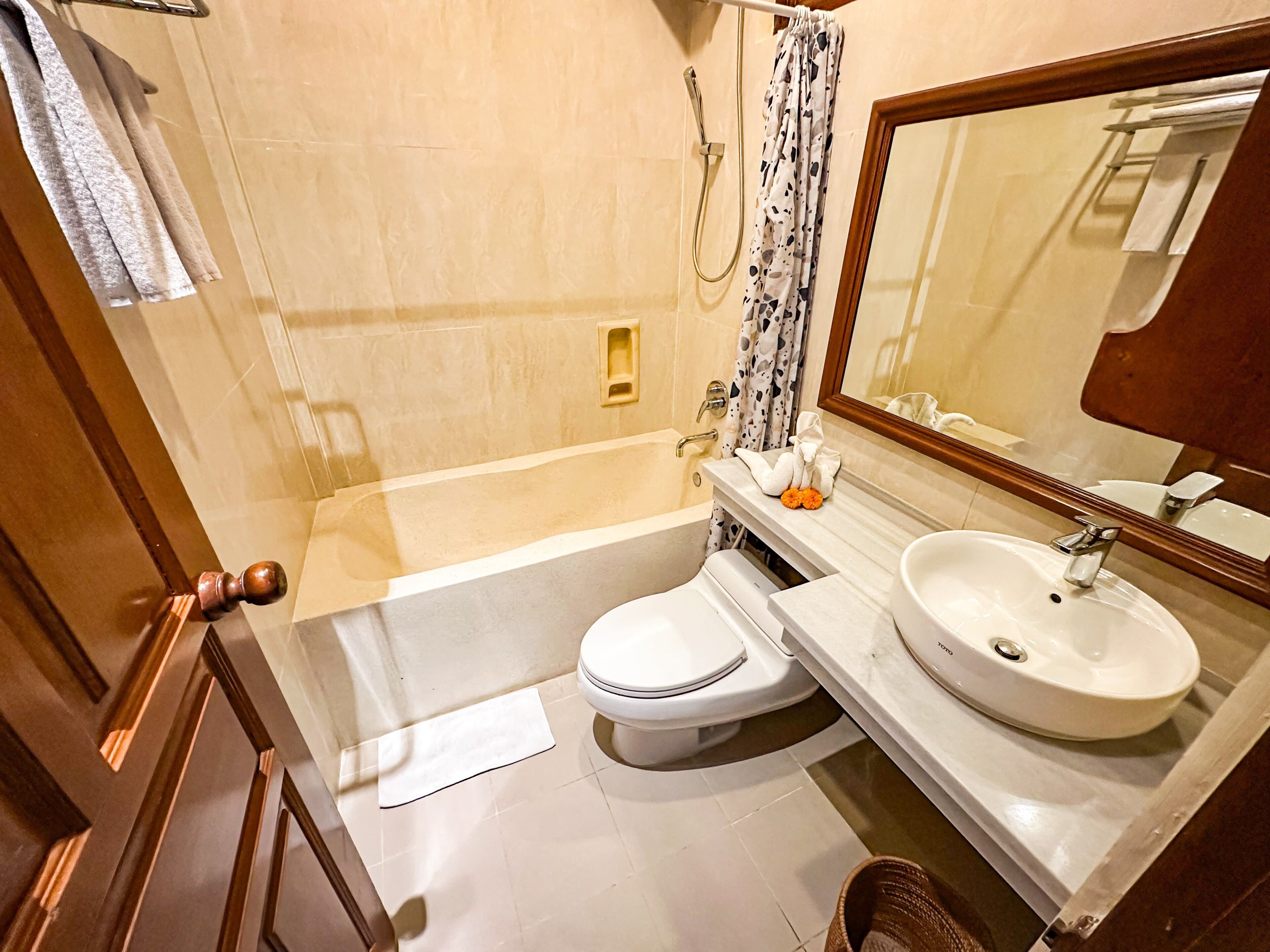 Bañera con ducha, toallas, jabón, shampoo