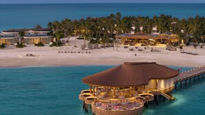 An overwater resort with a circular building, a beach area, and a pool. - Centara Grand Lagoon Maldives (Kodhipparu Falhu)