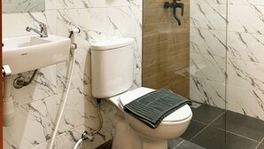 Un baño con inodoro, lavamanos y ducha.