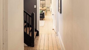 A hallway with a staircase, a dining area, and a kitchen visible through an archway. - Barkly Terrace | Carlton's Charming Heritage (Carlton)