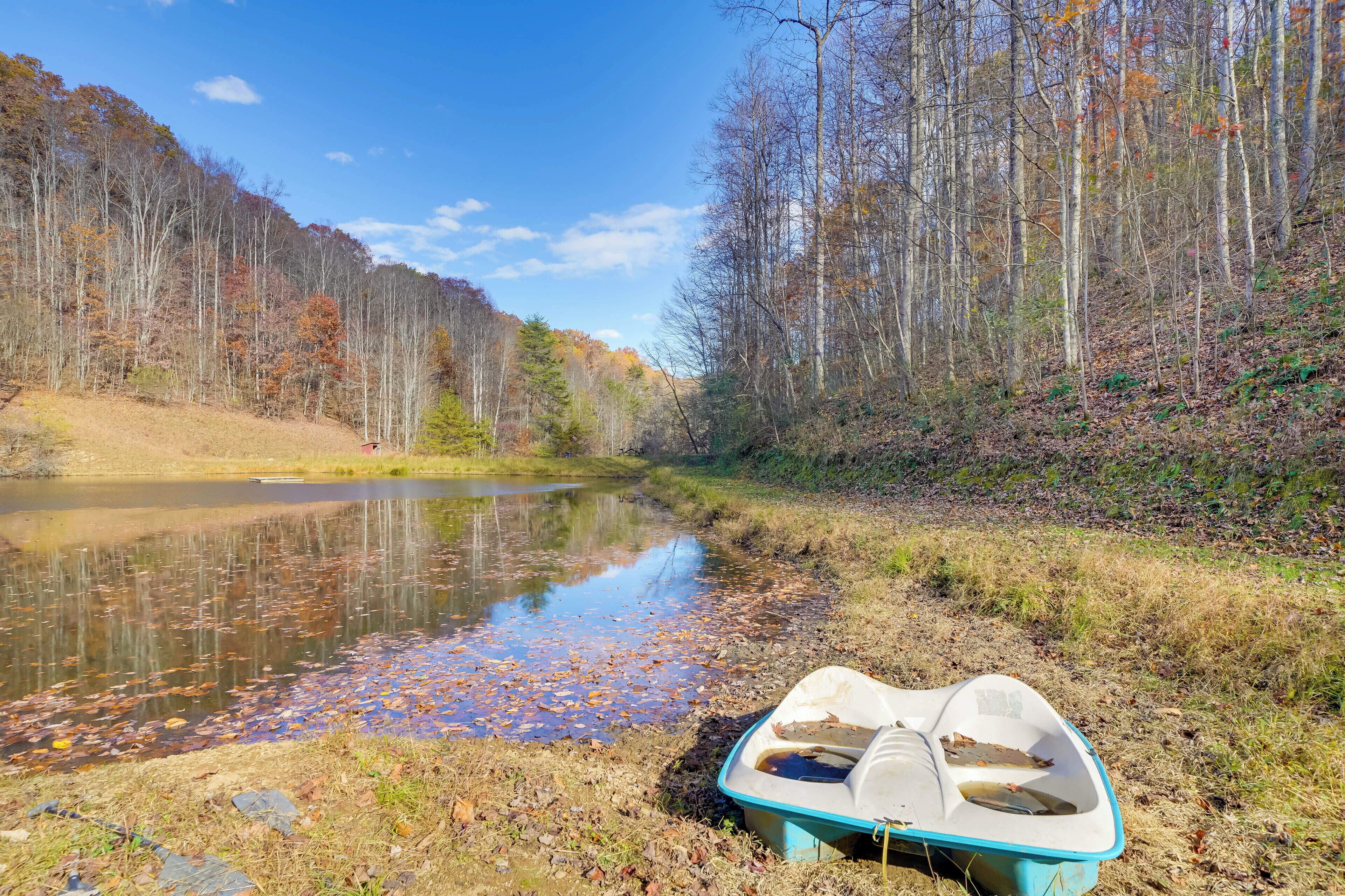 A boat on a riverbank with trees and a clear sky.