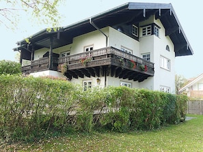A two-story house with a balcony, surrounded by greenery. - Vacation apartment in Haus Wagner with 2 separate bedrooms, 74 m², 2nd floor, access to the terrace (Prien am Chiemsee)