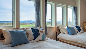A hotel room with two beds, large windows, and a view of the landscape. - CLEMATIS (Nakafurano)