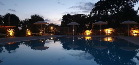 Una piscina al aire libre, sillones reclinables de piscina