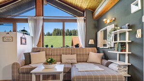 Ein gemütliches Wohnzimmer mit einer Couch, einem kleinen Tisch und einem Bücherregal.