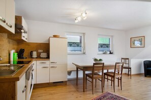 Una cocina moderna con armarios de madera, una mesa de comedor con sillas y un ventanal con vistas.