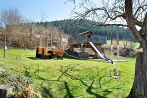 A playground with a slide, swings, and a wooden structure. - Apartment 'Ferienwohnung Felix' with Balcony and Wi-Fi (Meßstetten)