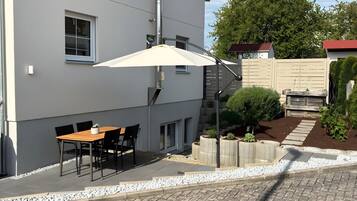 A building with a patio area, outdoor seating, and a garden.
