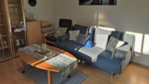 Moderni olohuone, jossa on sohva, sohvapöytä ja kaappi.