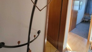 Käytävä, jossa on puinen ovi, peili ja naulakko, joka on koristeltu sydämenmuotoisilla koristeilla.