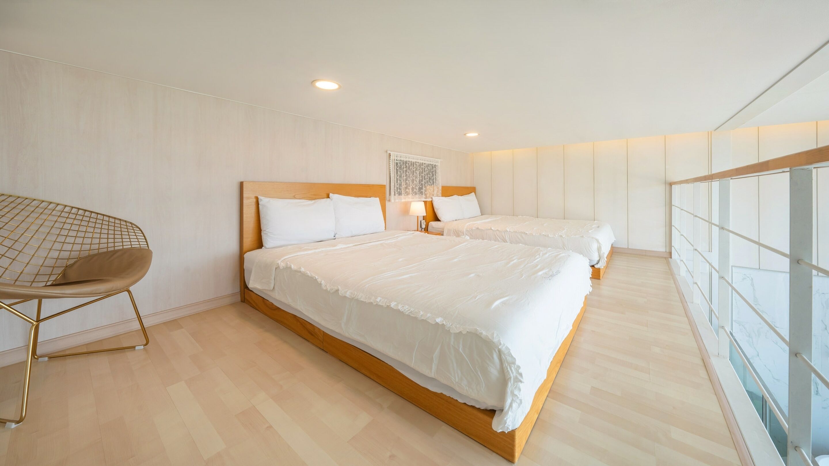 Una habitación de hotel moderna con dos camas, una silla y un ventanal grande.