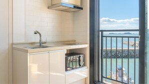 Una cocina con un lavamanos, una estufa y una ventana con vista al agua.