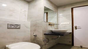 Un bagno con il water, un lavandino, uno specchio e una porta.