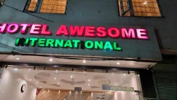 Un cartello di un hotel con luci al neon che riportano la scritta 'HOTEL AWESOME INTERNATIONAL'.