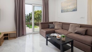 A modern living room with a brown sofa, a coffee table with a magazine, and a painting on the wall.