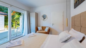 Una habitación de hotel con cama, sofá, espejo redondo y puerta.