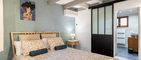 Une chambre à coucher avec un grand lit, une table de chevet avec une lampe et un tableau au mur.