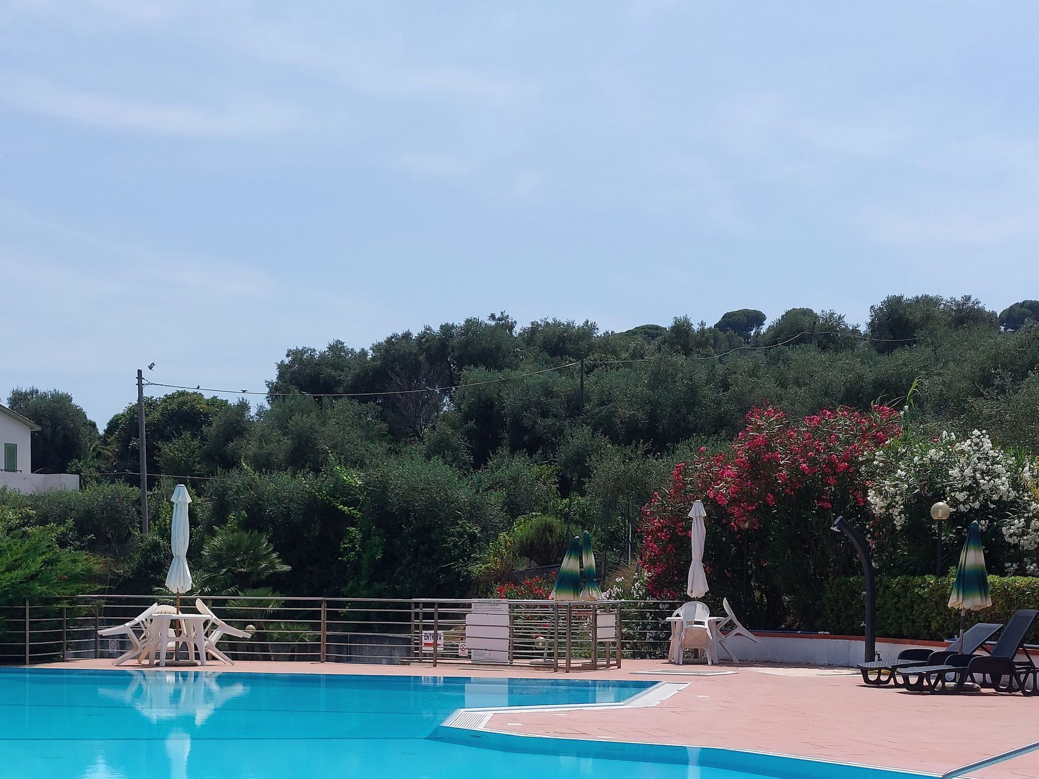 A swimming pool with lounge chairs and a fountain.