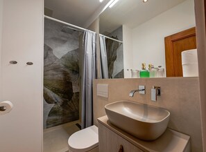 Un baño moderno con ducha, inodoro y lavamanos.