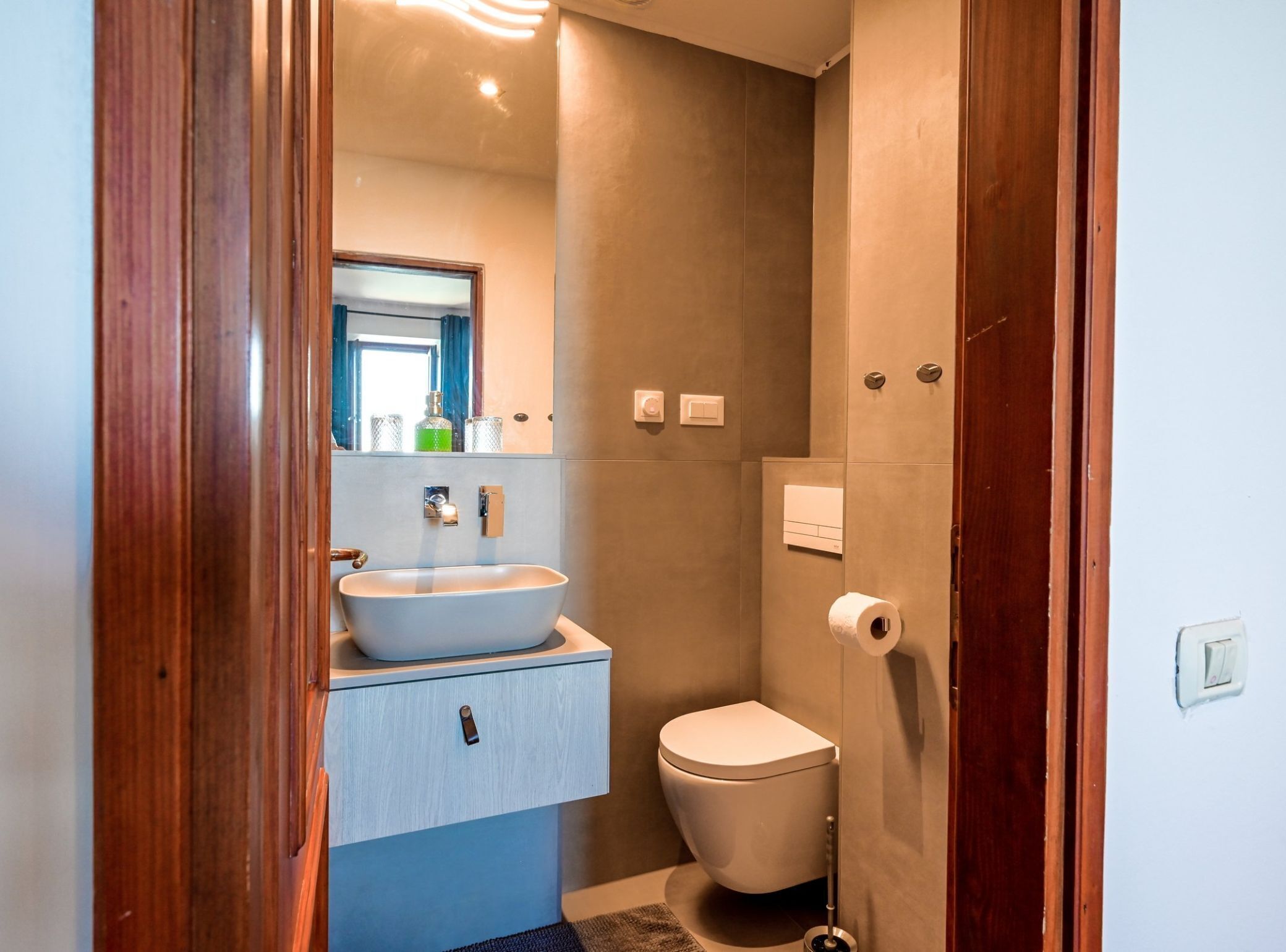 Ein modernes Badezimmer mit freistehender Waschtisch, Toilette und Duschbereich.