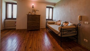 A bedroom with a wooden floor, a bed with a metal frame, a dresser, and a window. - Seaside Escape Rovinj Old Town Apartment (Rovinj)