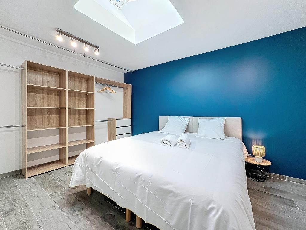 A bedroom with a bed, a wardrobe, and a nightstand.