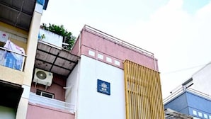 A multi-story building with a vertical bamboo fence, air conditioning units, and a visible balcony. - Kivi stays  (Pune)