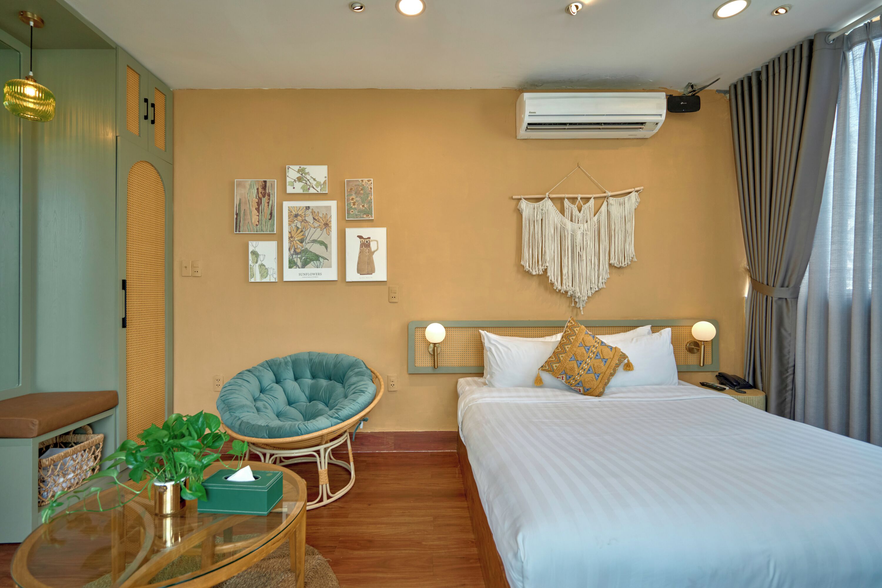 Une chambre d’hôtel avec un lit, une chaise, une table et des œuvres d’art murales.
