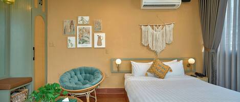 Une chambre d’hôtel avec un lit, une chaise, une table et des œuvres d’art murales.