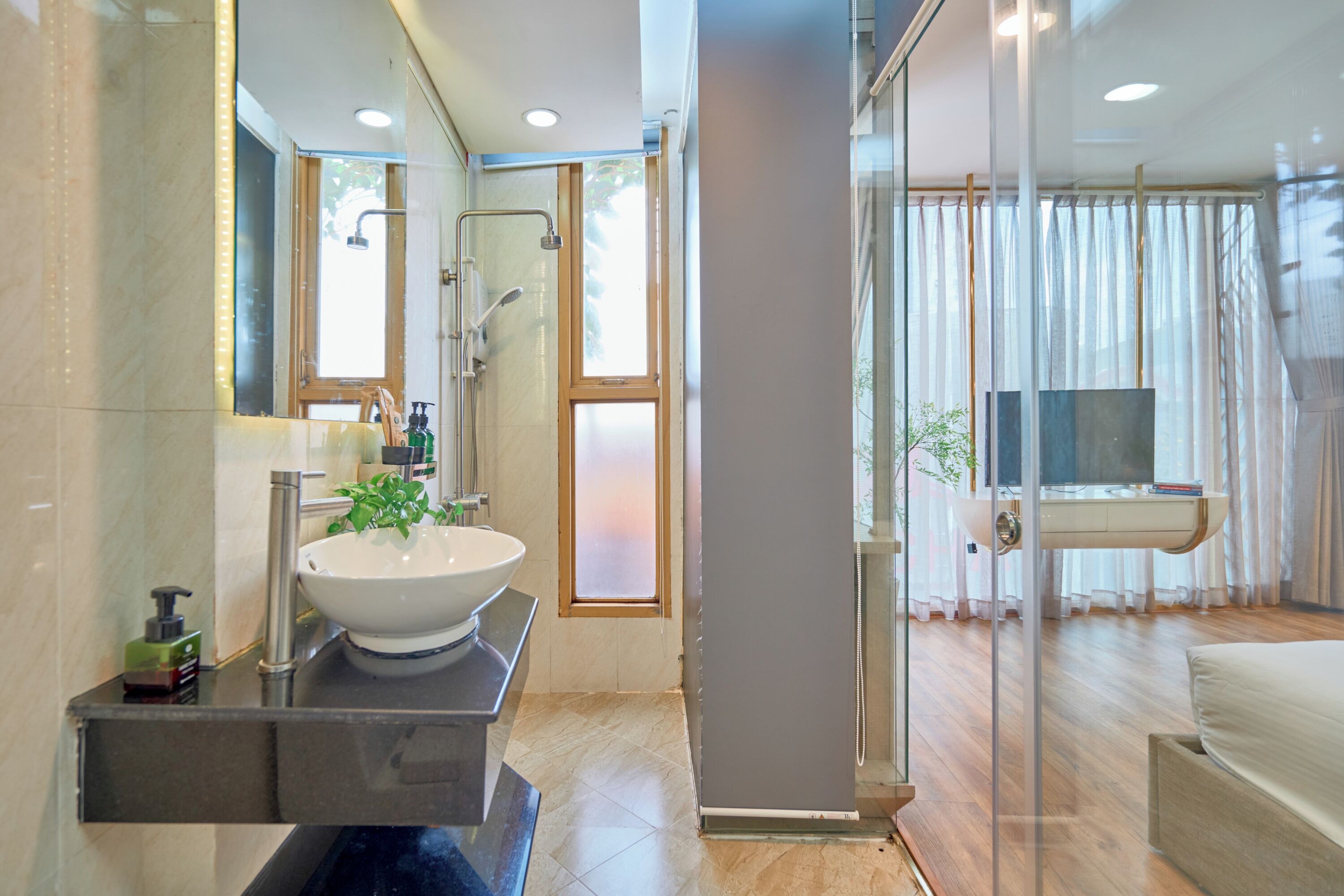 A modern bathroom with a large sink, mirror, and shower.