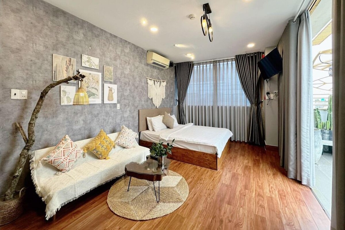 Um quarto moderno com cama, sofá, mesa de centro e televisão.
