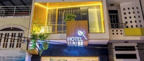 Ein Hotel mit modernem Design, das mehrere Balkone und ein großes 'HOTEL'-Schild zeigt.