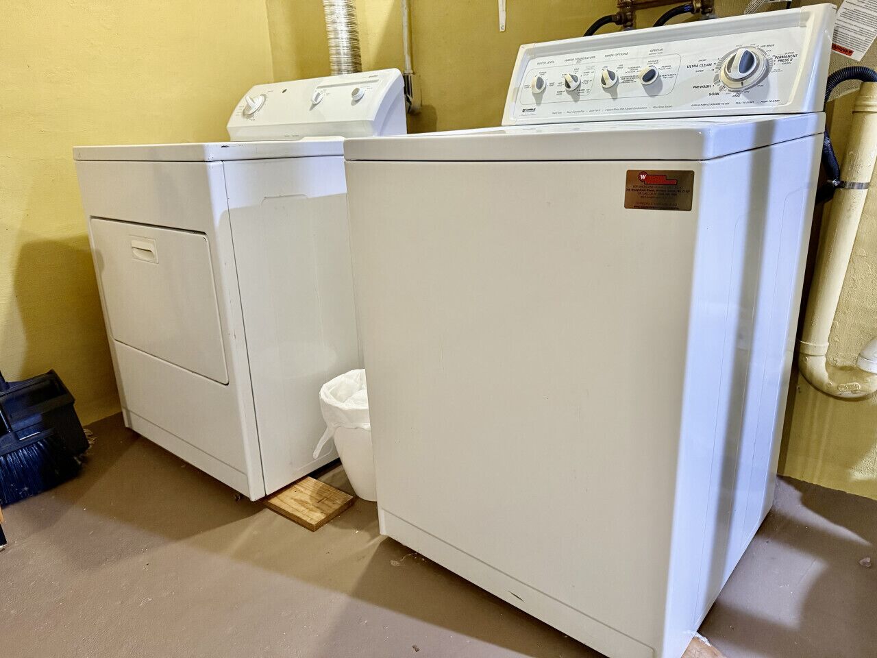 A laundry room with two front-loading washers and a white toilet.